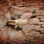 fist punching through a brick wall